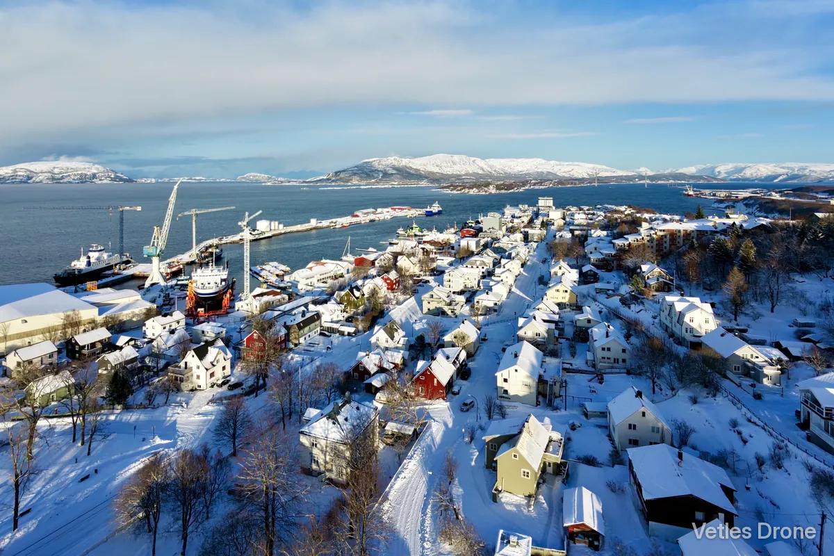 Sandnessjøen med verft, kaier og havneområde en solrik vinterdag, sett fra drone